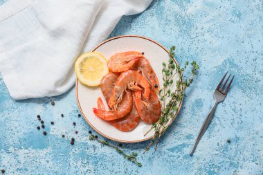 Lezzetli haşlanmış karides, limon ve biberli açık mavi zemin