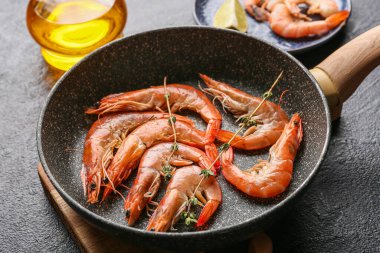 Koyu arkaplanda lezzetli haşlanmış karidesli kızartma tavası