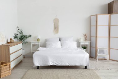 Büyük yataklı, masalı ve tuvaletli aydınlık yatak odasının içi.