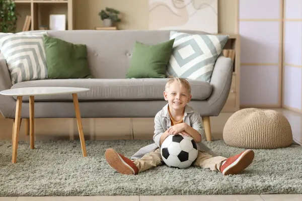 Evde futbol topu olan sevimli bir futbolcu.