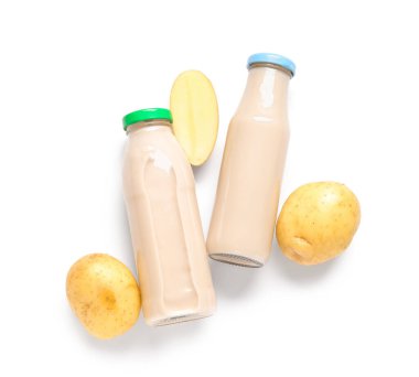 Bottles of tasty potato milk on white background clipart