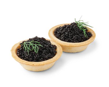 Tasty tartlets with black caviar on white background