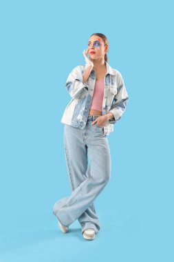 Mavi arka planda yüzü boyalı genç bir kadın.