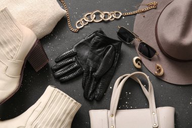 Siyah deri eldivenli kompozisyon ve siyah arka planda şık kadın aksesuarları.