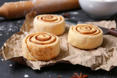 Siyah arkaplanda pişmemiş tarçın ruloları