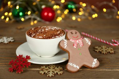 Bir fincan lezzetli kakao, Noel kurabiyesi ve ahşap masa süsleri.