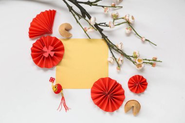 Çin sembolleri, fal kurabiyeleri ve beyaz arka planda çiçek dalıyla dolu boş bir kart. Yeni yıl kutlaması