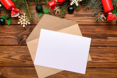 Zarflı boş kağıt ve ahşap arka planda Noel süsü. Noel Baba 'ya mektup