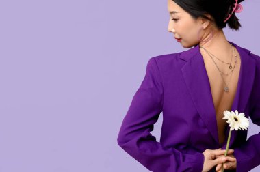 Leylak arka planında beyaz Gerbera çiçeği olan güzel bir Asyalı kadın.