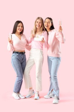 Pembe arka planda şampanyalı ve pastalı genç kadınlar. Kız Partisi