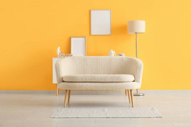 Oturma odasında lamba ve halı olan rahat beyaz bir kanepe.