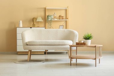 Beyaz kanepe, sehpa ve çiçekli bir oturma odası.