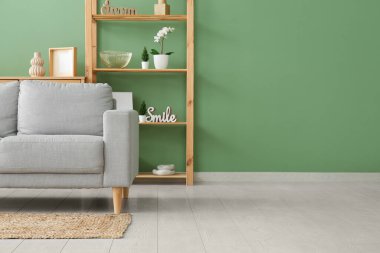 Oturma odasının içinde yumuşak kanepe ve raf ünitesi var.