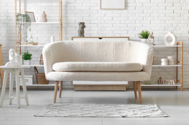 Oturma odasında rafları olan rahat beyaz bir kanepe.