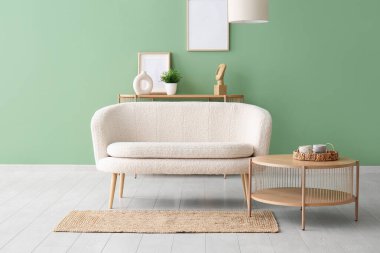 Oturma odasında kahve masası ve halısı olan rahat beyaz bir kanepe.