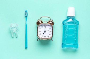 Çalar saat, plastik diş, diş macunu ve diş fırçası.