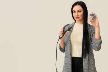 Açık arkaplanda saç eklentisi için aletleri olan kadın kuaför.