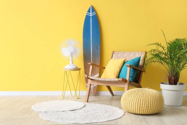 Koltuğu, sehpası ve sörf tahtası olan şık bir oturma odası.