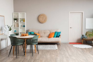 Rahat kanepesi, yemek masası, sandalyeleri ve halısı olan güzel bir oturma odası.