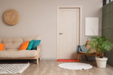 Rahat kanepesi, koltuğu, yastıkları ve çiçekleri olan güzel bir oturma odası.