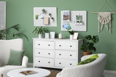 Beyaz çekmeceleri, kanepesi, sehpası ve tahtasıyla güzel bir oturma odası.