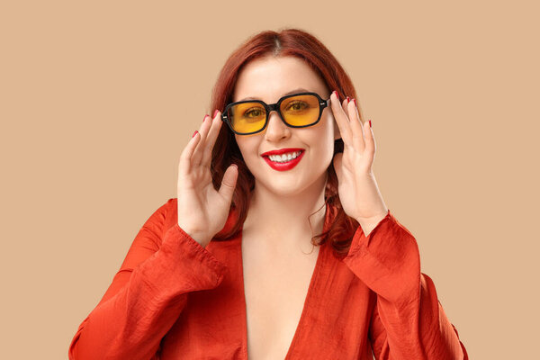 Модная молодая женщина в стильных солнечных очках на коричневом фоне