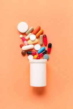 Şişeli kompozisyon ve renkli arka planda haplar