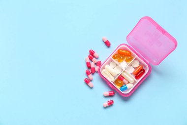 Renk arkaplan üzerinde farklı haplar bulunan pembe bir kap
