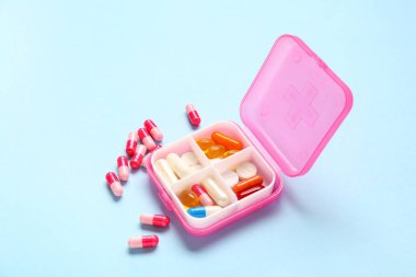 Renk arkaplan üzerinde farklı haplar bulunan pembe bir kap