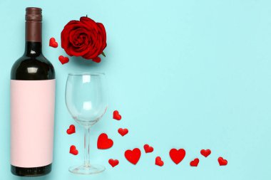 Mavi arka planda Sevgililer Günü için bir şişe şarap ve gül çiçeği kompozisyonu