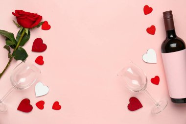 Sevgililer günü için şarap, bardak ve gül çiçekli çerçeveli pembe arka planda.
