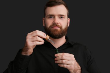 Esmer arka planda gerekli yağı olan yakışıklı sakallı adam.