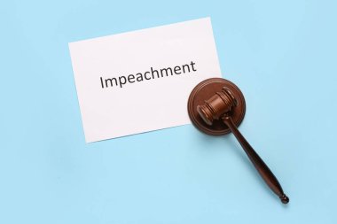 Beyaz arka planda IMPEACHMENT sözcüğüyle Yargıç Tokmak ve kağıt