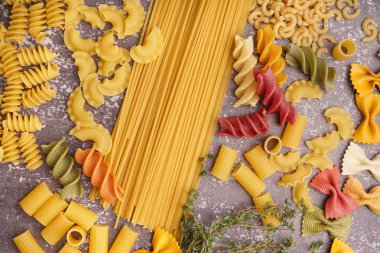 Gri grunge arkaplanda farklı pişmemiş makarna