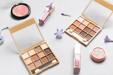 Dudak parlatıcılarıyla, fosforlu kalemle ve beyaz arkaplanda çiçeklerle göz falı paletleri