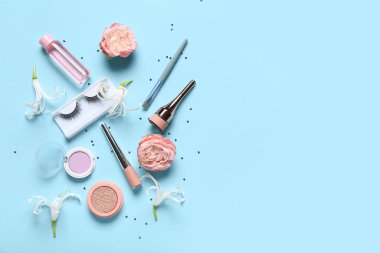 Mavi arka planda çiçekli makyaj ürünleri ve konfeti
