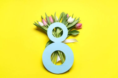 Şekil 8 kağıttan ve sarı arkaplanda güzel lalelerden yapılmış bir buket. Uluslararası Kadınlar Günü