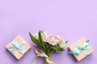 İçinde bir buket güzel lale ve mor arka planda ortanca çiçekleri olan hediye kutuları. Uluslararası Kadınlar Günü