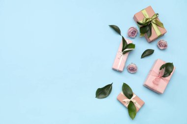 İçinde güzel güller ve mavi arka planda yapraklar olan hediye kutuları. Uluslararası Kadınlar Günü