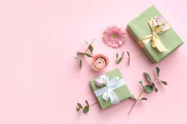 Pembe arka planda gül ve gerbera çiçekli hediye kutuları. Uluslararası Kadınlar Günü