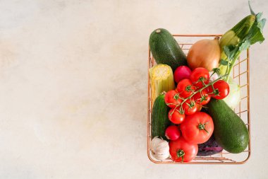 Beyaz arka planda farklı taze sebzelerle dolu sepet.