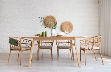 Odada okaliptüs dalları olan sandalyeler ve yemek masaları.