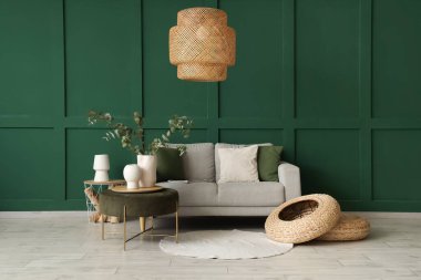 Rahat bir kanepe ve okaliptüs vazosu şık oturma odasındaki sehpanın üzerinde.