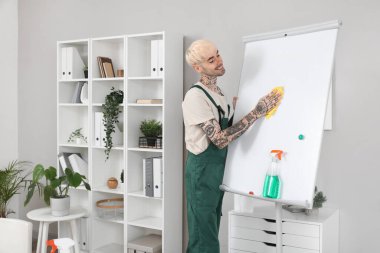 Erkek hademe ofiste pano temizliyor.