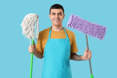 Mavi arka planda yer paspası olan erkek hademe.