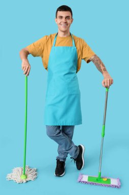 Mavi arka planda yer paspası olan erkek hademe.