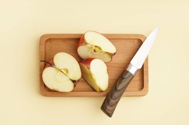 Tahta tahta tahta, sarı arka planda taze kırmızı elma.