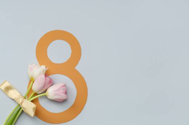 Şekil 8 kağıttan yapılmış ve gri arkaplanda güzel laleler var. Uluslararası Kadınlar Günü
