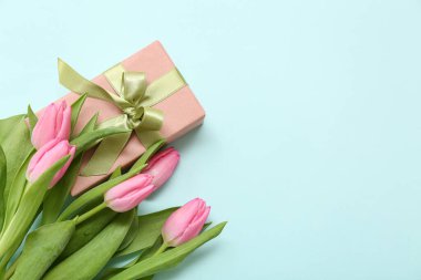 Hediye kutusu ve mavi arka planda güzel laleler. Uluslararası Kadınlar Günü