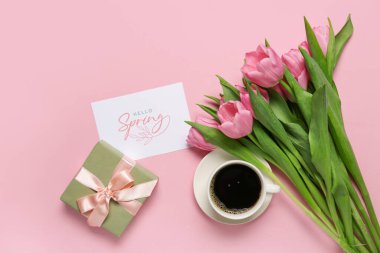 Mesajlı tebrik kartı Hello İlkbaharı, güzel laleler, hediye kutusu ve pembe arka planda bir fincan kahve